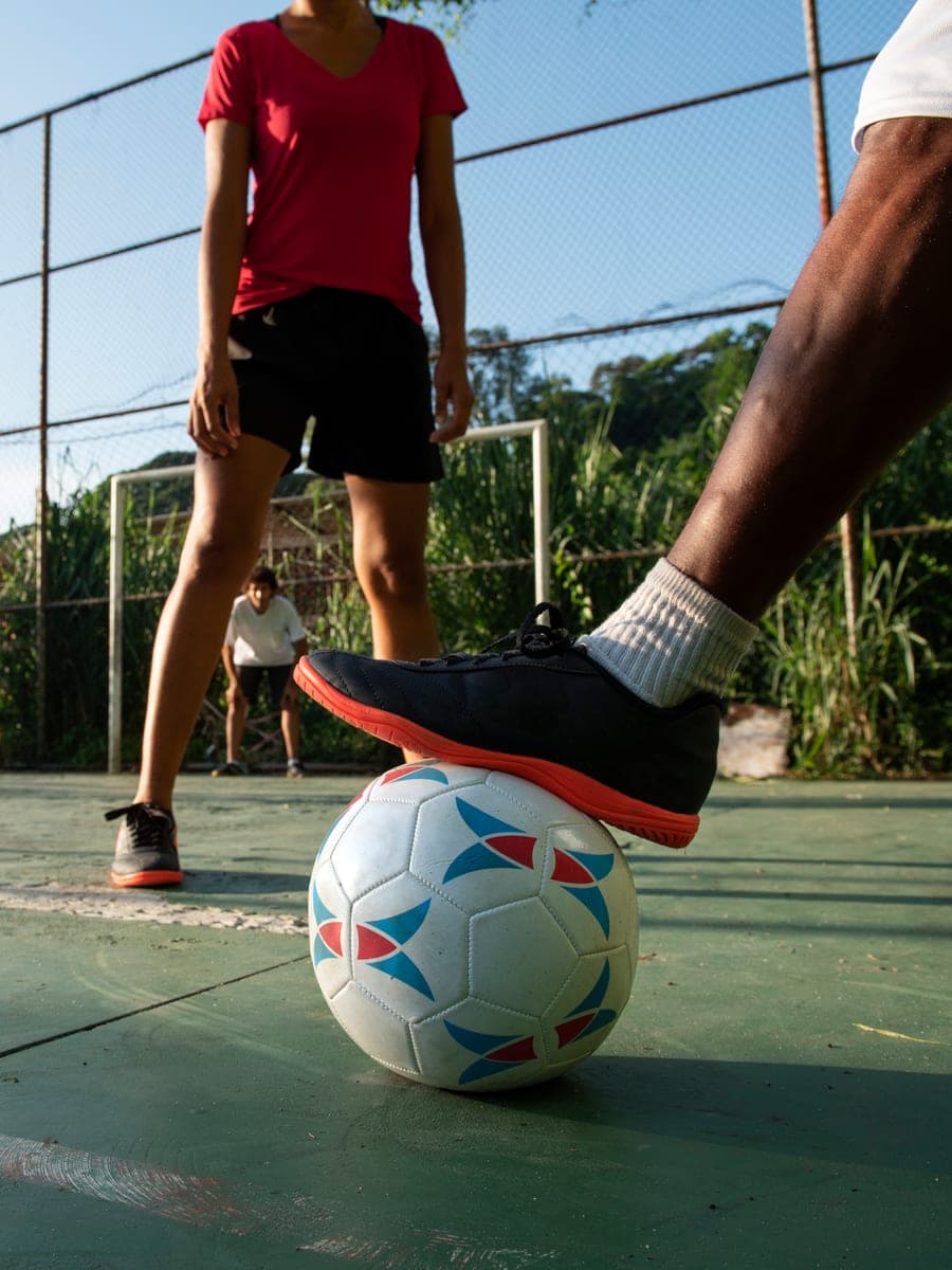 Quadra de futsal coberta com jogadores em partida